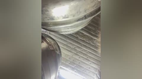 Media: Video of a stainless steel pot filled with frothy, bubbling liquid, positioned on a textured, light gray countertop with a grid pattern.