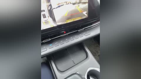 Media: Video of a car interior showing a mounted GPS screen displaying road signs, a black control panel, and a black steering wheel, set against a blurred background.