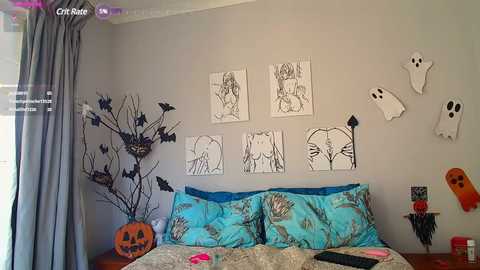 A video of a Halloween-themed bedroom with a gray wall adorned with black bats, a jack-o'-lantern, and a ghostly scene. A bed with turquoise pillows and a bedspread featuring a pumpkin pattern is visible.