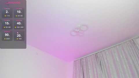 A video of a dimly lit room with soft, pinkish-purple lighting. A ceiling-mounted light fixture emits a diffused glow. To the left, a thermostat with various temperature readings is visible. Gray curtains partially cover a window in the background.