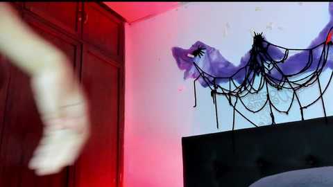 Video of a person in motion, blurred legs, white socks, and black shoes, against a wall with a purple spider web drawing and a red glow, suggesting a spooky, suspenseful atmosphere.