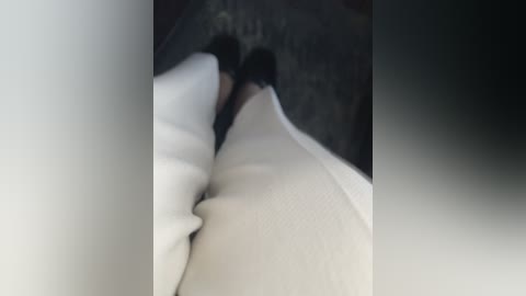 Media: A blurred video of a person with fair skin, lying on their side, wearing white pajamas, in a dimly lit room. The background is out of focus, creating a sense of intimacy and privacy.