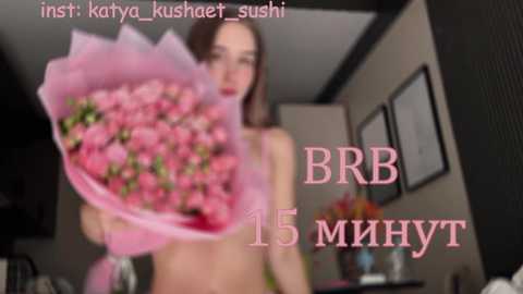 Media: A blurred video of a young woman with long brown hair, holding a bouquet of pink flowers, with text in Russian.
