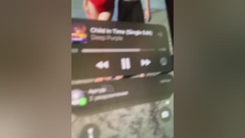 A blurry video of a smartphone screen displaying the \"Play\" button and album art for \"City of Angels\" by Twenty One Pilots.