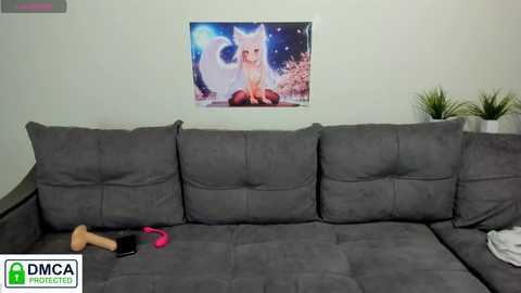 Media: Video of a modern, grey sectional sofa adorned with plush cushions, featuring a vibrant, digital fox art poster on the wall. The sofa is cluttered with a pink vibrator, a black sex toy, and a stuffed fox toy.