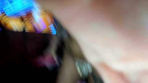 Media: A blurry, out-of-focus video shows a close-up of a person's face, with indistinct features and vibrant blue and purple hues in the background, creating a surreal, dreamlike effect.