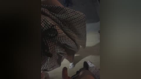 A video showing a man in a patterned shirt lying on a bed, surrounded by shadows and dim lighting, suggesting a private, possibly intimate setting.