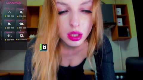 Video of a young woman with long blonde hair, wearing bold pink lipstick, in a dimly lit room with kitchen cabinets and a virtual live stream overlay.