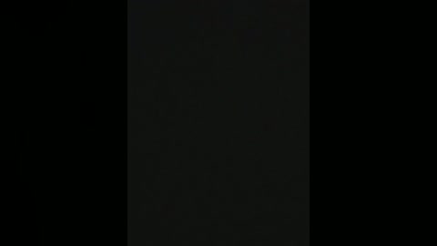 A video featuring a black, vertical rectangular object against a completely black background, creating a stark contrast and minimalistic aesthetic.