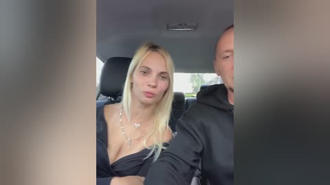 Media: A video shows a blonde woman in a black top, kissing a bald man, sitting in a car.