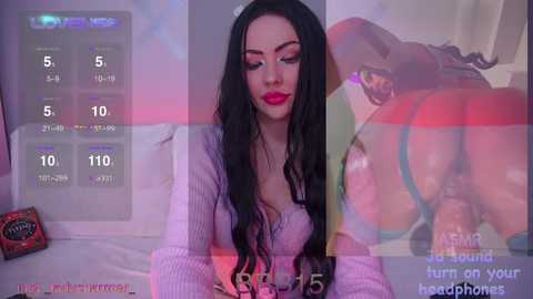 A video of a young woman with long black hair, wearing a pink knitted sweater, lying on a bed with a digital clock and a red apple nearby.