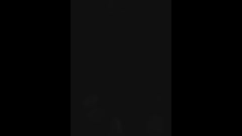 A video of a black wall with a subtle, barely visible vertical line in the center, creating a minimalist, monochromatic aesthetic.