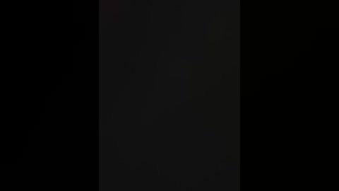 Video of a black vertical stripe centered on a dark background, with subtle texture and slight shadow variations. No discernible objects or details.