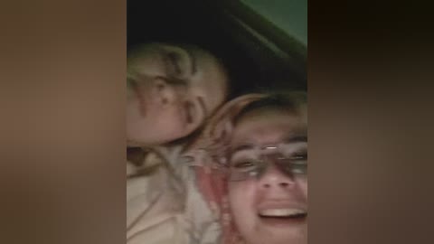 A video shows two young children with blood on their faces, smiling, and lying on a bed. The image has a grainy, low-resolution quality.