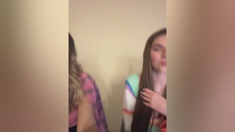 Media: A blurry video of two women in casual attire, possibly in a bathroom, with one holding her hair.