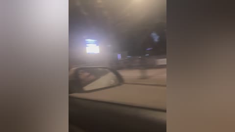A blurred video captures a nighttime street scene with dimly lit buildings, a glowing sign, and a car's interior visible. The image is grainy, making details hard to discern.