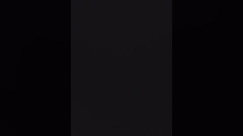 Video of a black vertical rectangle in a dark, empty space, with subtle, barely visible textures and a hint of light at the center, creating an enigmatic, minimalist aesthetic.