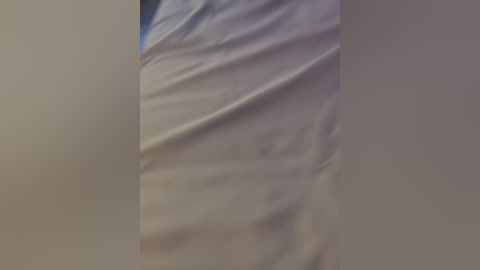 Media: Video of a person lying on a bed with wrinkled white sheets, partially visible face, blurred background, capturing a relaxed moment.