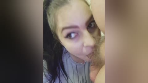 Video of a close-up of a young woman with dark hair, light skin, and a slight goth aesthetic, performing oral sex on a man with a light skin tone.
