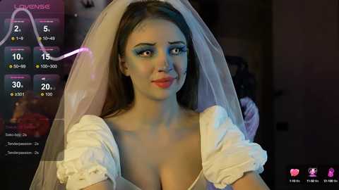 Media: A CGI image of a fair-skinned woman with blue eyeshadow, wearing a white dress and veil, with a \"LOVE\" heart above her head.