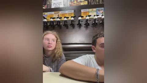 Media: Video of a young blonde girl and a young man with short hair in a restaurant, with a wall of toy motorcycles in the background.