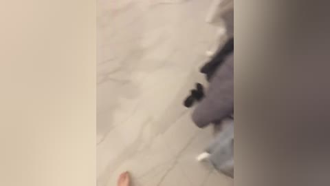 A blurry video showing a white wall with faint streaks, likely caused by water damage. The image has a soft focus, making it difficult to discern details.