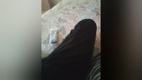 Video of a person's black sock on a beige carpet with a white plastic bag and a dark shoe partially visible.