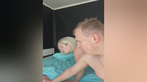 Media: A video captures a nude elderly couple, with the man's face partially obscured by a large, vertical filter, lying on a bed covered in light blue sheets.