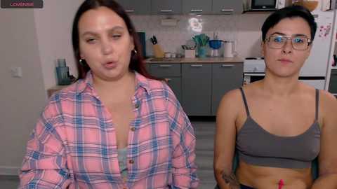 Media: Video of two women in a modern kitchen; one in a plaid shirt, the other in a gray crop top.
