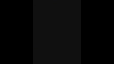 A black-and-white video features a vertical, central black stripe set against a black background, creating a stark contrast. The image lacks discernible objects or textures, focusing solely on the simple, minimalist composition.