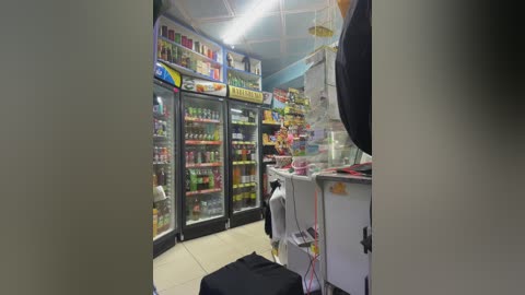 Media: Video of a well-lit, colorful convenience store with brightly lit refrigerators filled with drinks, fluorescent lights overhead, and various snacks displayed.