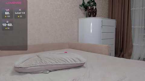 Video of a bedroom with a bed, a white dresser, and a potted plant; a digital overlay shows temperature and humidity levels.