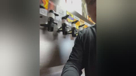 Media: A video of a person wearing a black shirt climbing a vertical ladder with handholds and safety harnesses, against a white and orange-striped background, possibly in a training or industrial setting.