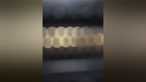 Media: A blurred video featuring soft, circular bokeh lights in varying shades of white, yellow, and green, with a dark background. The image appears to be taken at night, possibly in a city setting.