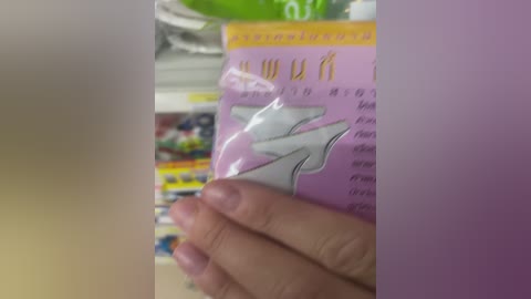 Media: A video of a hand holding a purple package with Chinese characters and a white \"7\" symbol, blurred background reveals colorful product labels.