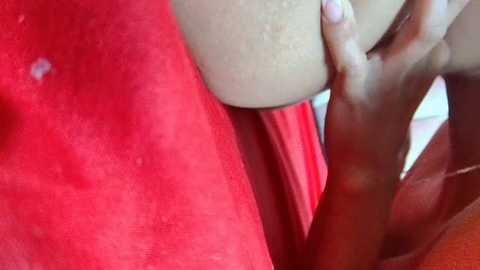 Media: Video of a close-up of a woman\u2019s hand on a red bra, showing a detailed view of her fingers and the bra's fabric texture.