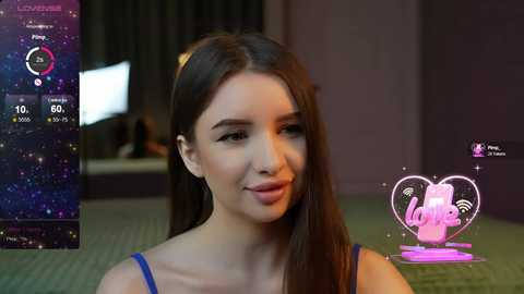 Media: A video of a young woman with long brown hair, wearing a blue tank top, smiling in a dimly lit room with a \"Lucky\" sign and a virtual reality headset display.