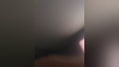 A blurred video features a person with fair skin and a large, round face, partially obscured by a white vertical column, creating a mysterious, abstract aesthetic.
