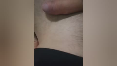 A close-up video of a light-skinned person's genital area, featuring a flaccid penis and testicles, partially obscured by black fabric. The image is intimate and candid, capturing natural skin texture and subtle pubic hair.
