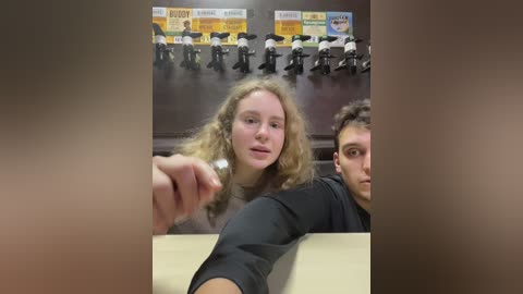 Media: Video of a classroom with a blonde woman and a man in the foreground, a group of students in the background.