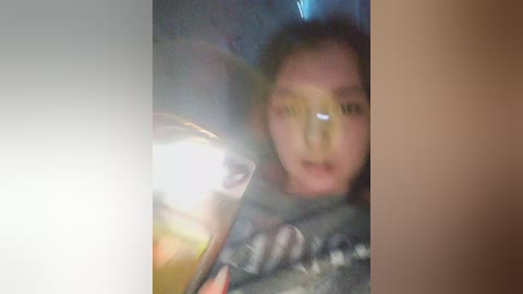 Media: A blurry video shows a young person with light skin and dark hair partially obscured by a metallic object, possibly a car hood.