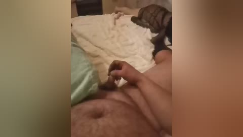 A video captures a close-up of a man with a light skin tone, lying on a bed with a beige blanket. He is holding a lighter and appears to be smoking a cigarette.