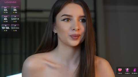 Media: Video of a young, fair-skinned woman with long, straight brown hair, wearing a white top. Background shows a virtual dating app interface with profile details. She has a serene expression.