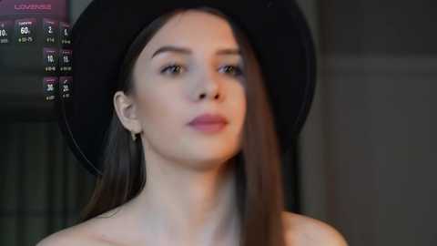 Media: Video of a young woman with long, straight brown hair, wearing a black hat and minimal makeup, set against a dimly lit background with a \"LOX\" menu on the left.