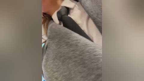 Media: A blurry video of a person wearing a grey suit jacket over a white shirt, with a black tie visible. The background is out of focus, and the image is grainy.