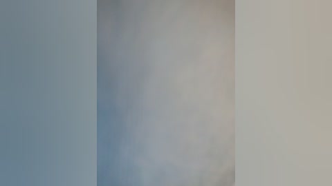 A blurred video of a wall with a gradient from light gray to pale beige, creating a soft, minimalist aesthetic. The image lacks distinct objects or people, emphasizing a serene, abstract composition.