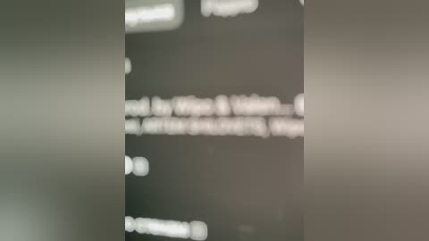 Video of a blurred, dark room with faint, white, bokeh lights in the background, creating a sense of depth and mystery. The image has a muted, moody atmosphere with indistinct shapes and textures.