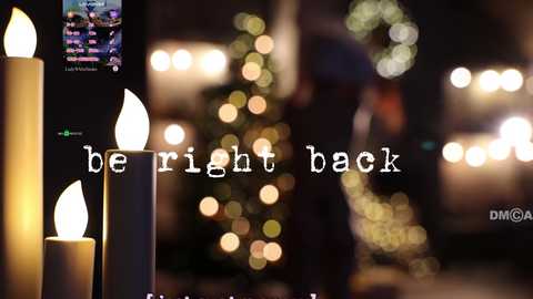 Media: Video of a festive scene with a dimly lit Christmas tree adorned with bokeh lights, a lit candle, and the text \"be right back\" overlaid.