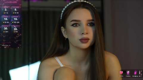 Media: Video of a young woman with long brown hair, wearing a white lace bralette, against a dimly lit, modern backdrop. A weather forecast screen shows temperatures and precipitation.