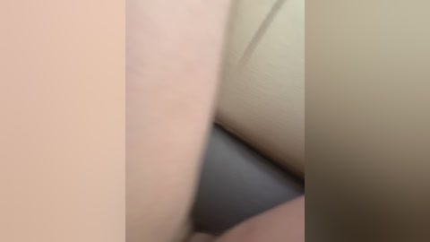 A close-up video of two pale, smooth buttocks pressed together, creating a soft, blurred outline. The background is neutral, possibly beige or light gray. The image is suggestive and lacks specific details about the individuals.